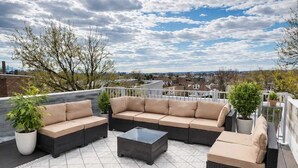 Een terras met een hoekbank, een bijzettafeltje en een potplant.
