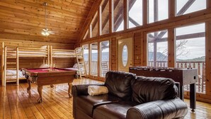 A cozy room with a pool table, leather sofa, and a foosball table. - Lookout Lodge by Avantstay Sleeps 18 Hot Tub Game Room Movie Theater View (Sevierville)