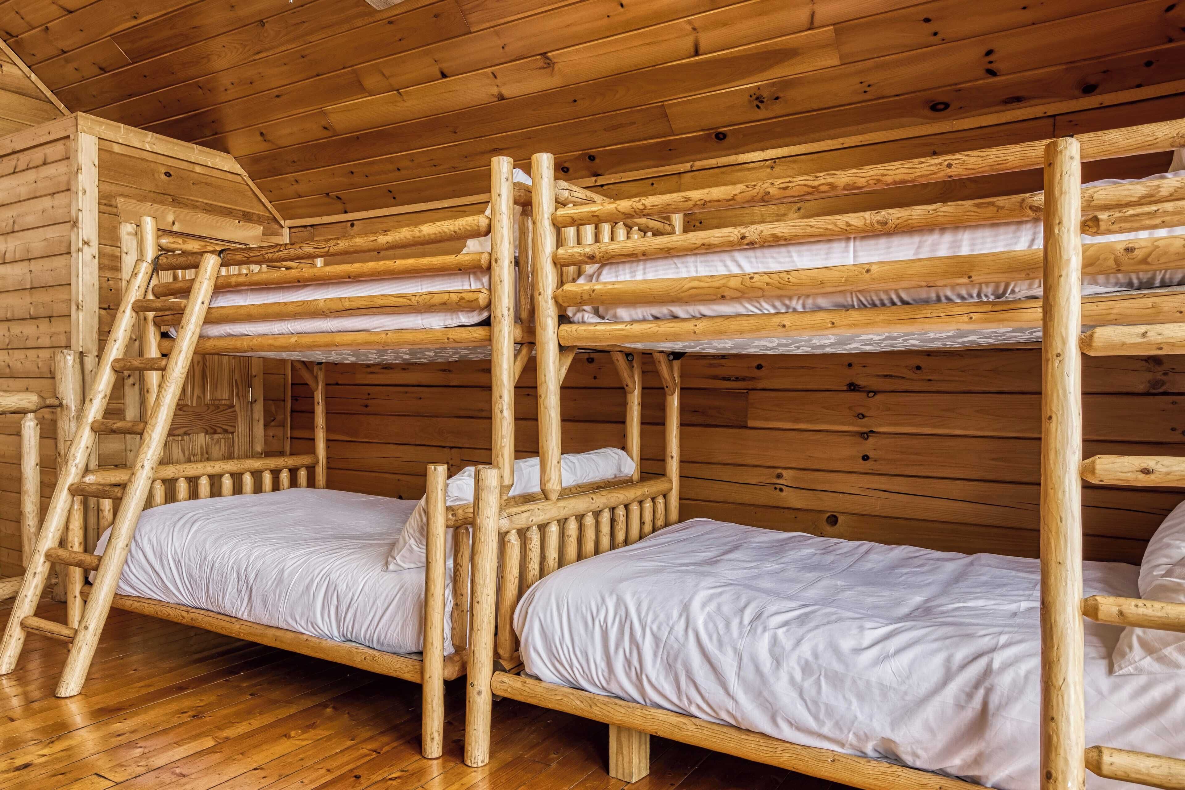 Uma cabana de madeira com beliches e escada.