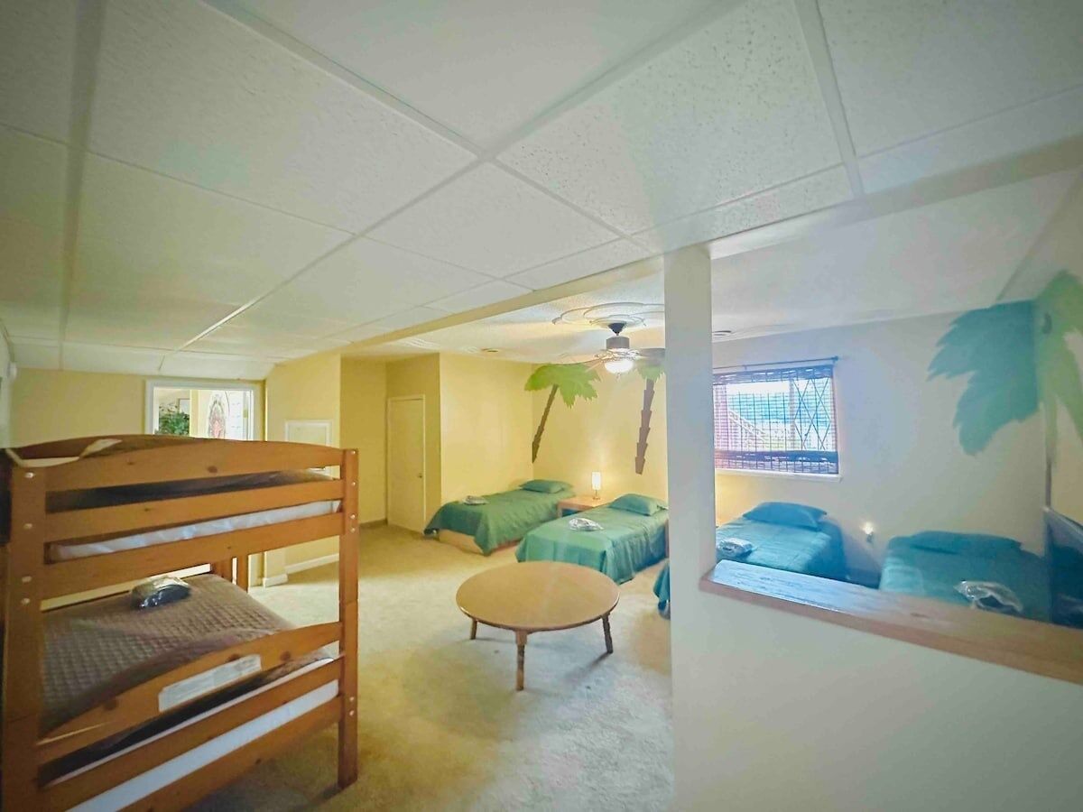 A room with bunk beds, a round table, and a ceiling fan.