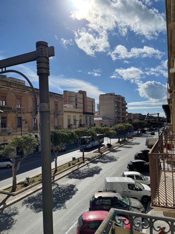 A street view with parked cars, a bus, and buildings.