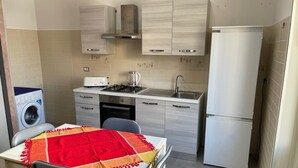 Eine kleine Küche mit Essbereich, einer Waschmaschine und einem Kühlschrank.