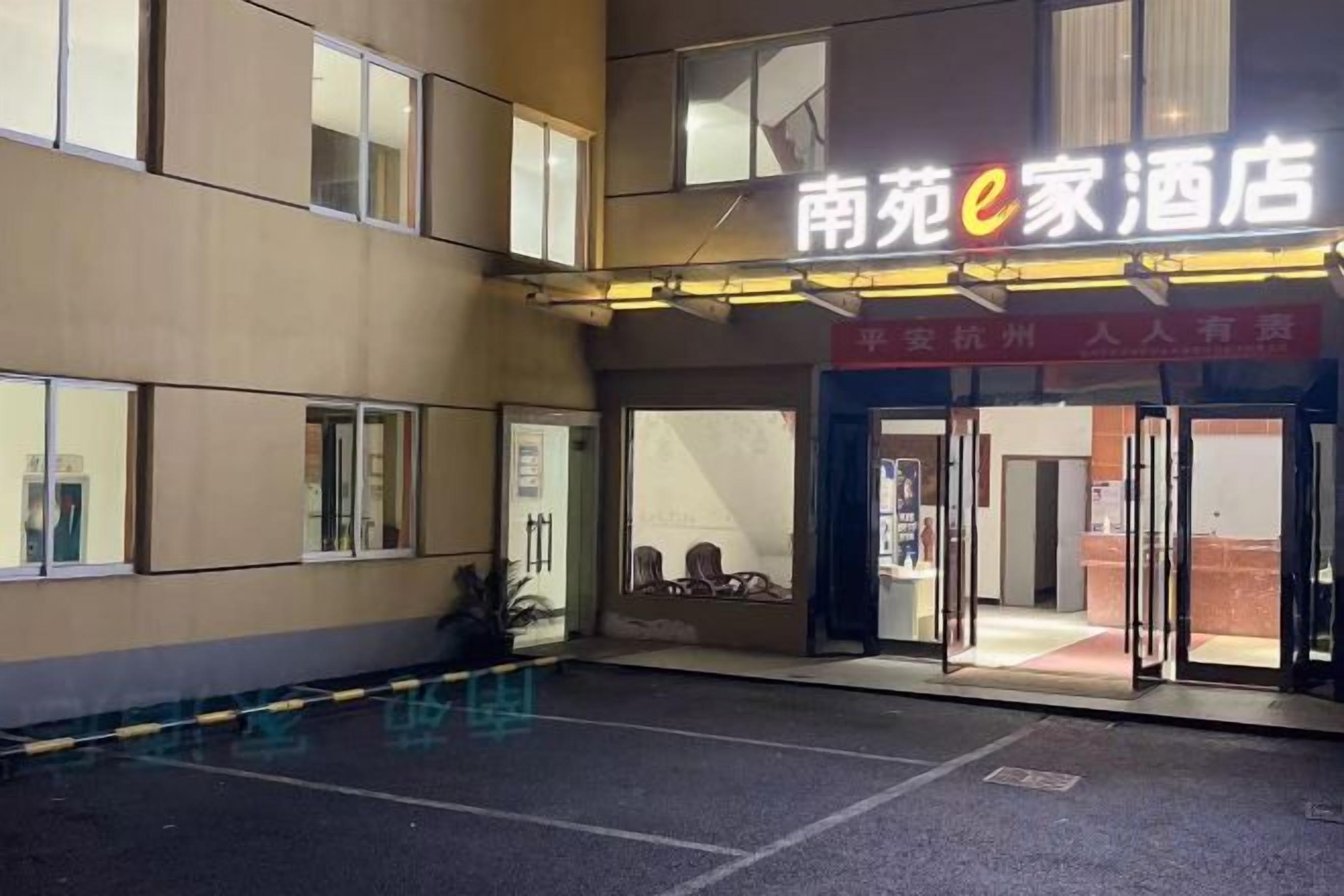 A hotel entrance with a sign reading '南苑e家酒店' and a red banner above the door.