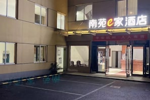 A hotel entrance with a sign reading '南苑e家酒店' and a red banner above the door. - NANYUAN INN Hotel (Hangzhou Huan Cheng North Road Baoshanqiao Subway Station) (Hangzhou)
