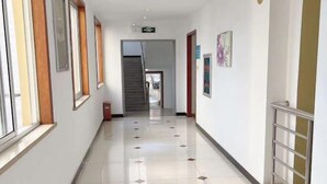 A corridor with a tiled floor, a staircase at the end, and a handrail on the right. - NANYUAN INN Hotel (Hangzhou Huan Cheng North Road Baoshanqiao Subway Station) (Hangzhou)