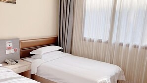 A hotel room with a single bed, a bedside table with a phone, and a window with curtains. - NANYUAN INN Hotel (Hangzhou Huan Cheng North Road Baoshanqiao Subway Station) (Hangzhou)