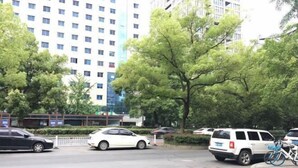 A parking area with multiple cars, a white SUV, and a bicycle. - NANYUAN INN Hotel (Hangzhou Huan Cheng North Road Baoshanqiao Subway Station) (Hangzhou)