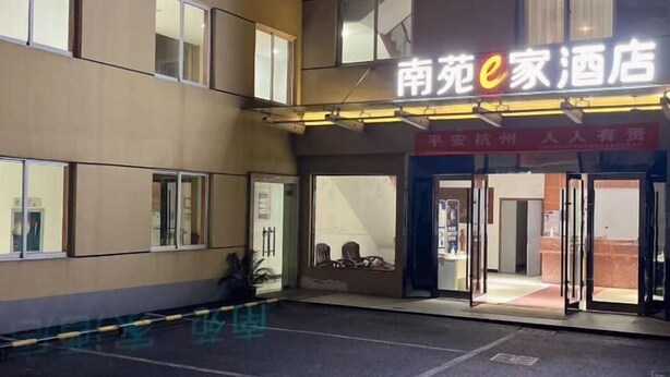 A hotel entrance with a sign reading "南苑e家酒店" and a red banner above the door. - NANYUAN INN Hotel (Hangzhou Huan Cheng North Road Baoshanqiao Subway Station) (Hangzhou)