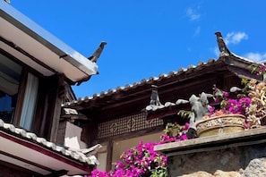A traditional building with a tiled roof and a stone base. - Jixiang Guanjing Inn (Lijiang Old Town Dashuiche Branch) (Lijiang)