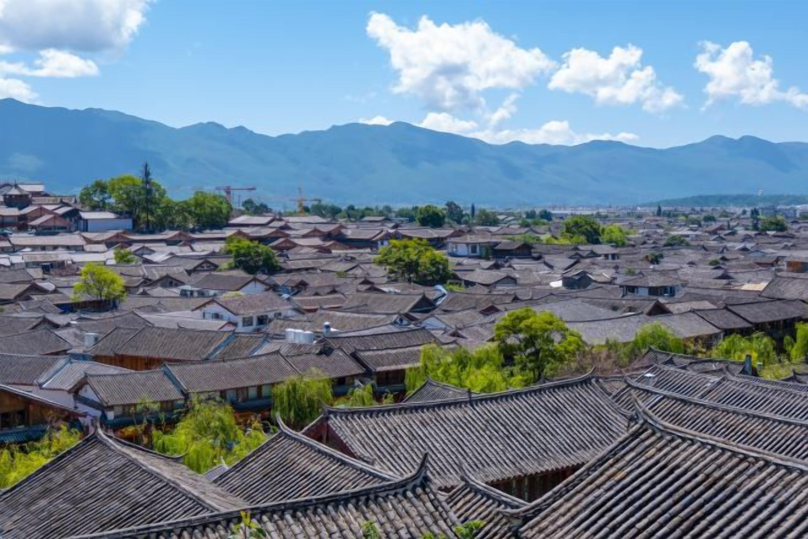 Un village traditionnel composé de plusieurs bâtiments, dont certains sont dotés de toits inclinés, le tout situé dans un cadre montagneux.