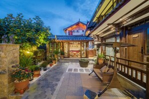 A traditional building with a tiled roof, a stone pathway leading to the entrance, and potted plants along the sides. - Jixiang Guanjing Inn (Lijiang Old Town Dashuiche Branch) (Lijiang)
