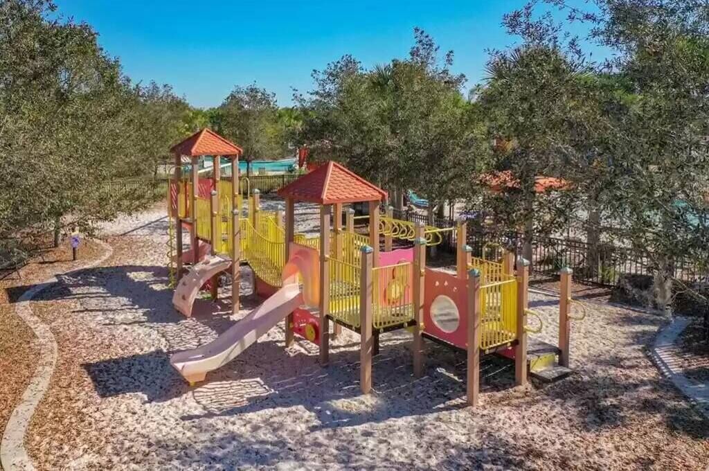A playground with a slide, climbing structures, and a covered area.