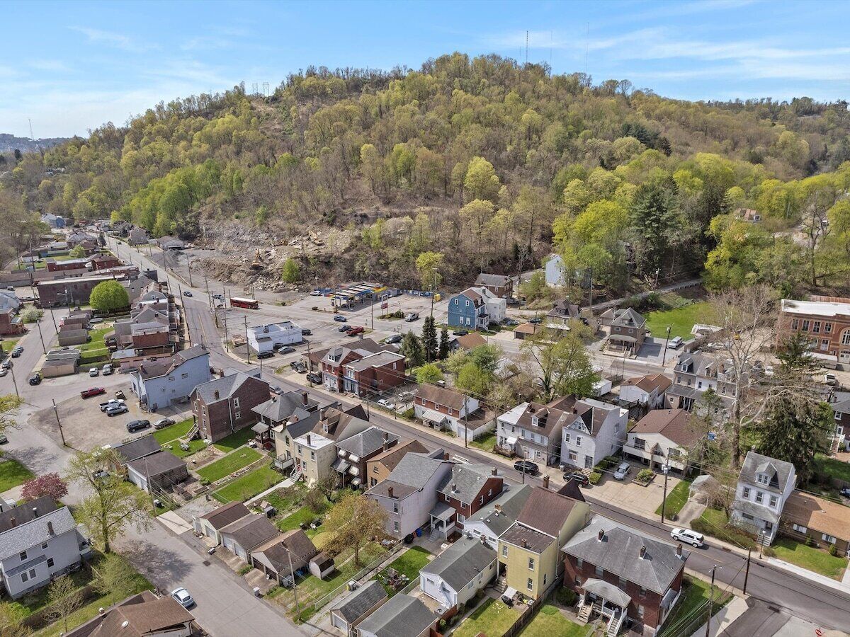 A residential area with houses, streets, and a hill in the background.