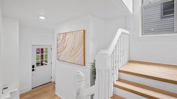 A staircase with white railings and wooden steps leading to a landing. - Shadyside, Central @4 Stylish and Central Studio with Free Parking (Pittsburgh)