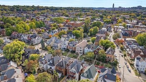 Vista aérea de una zona residencial con casas, calles y una torre a lo lejos.