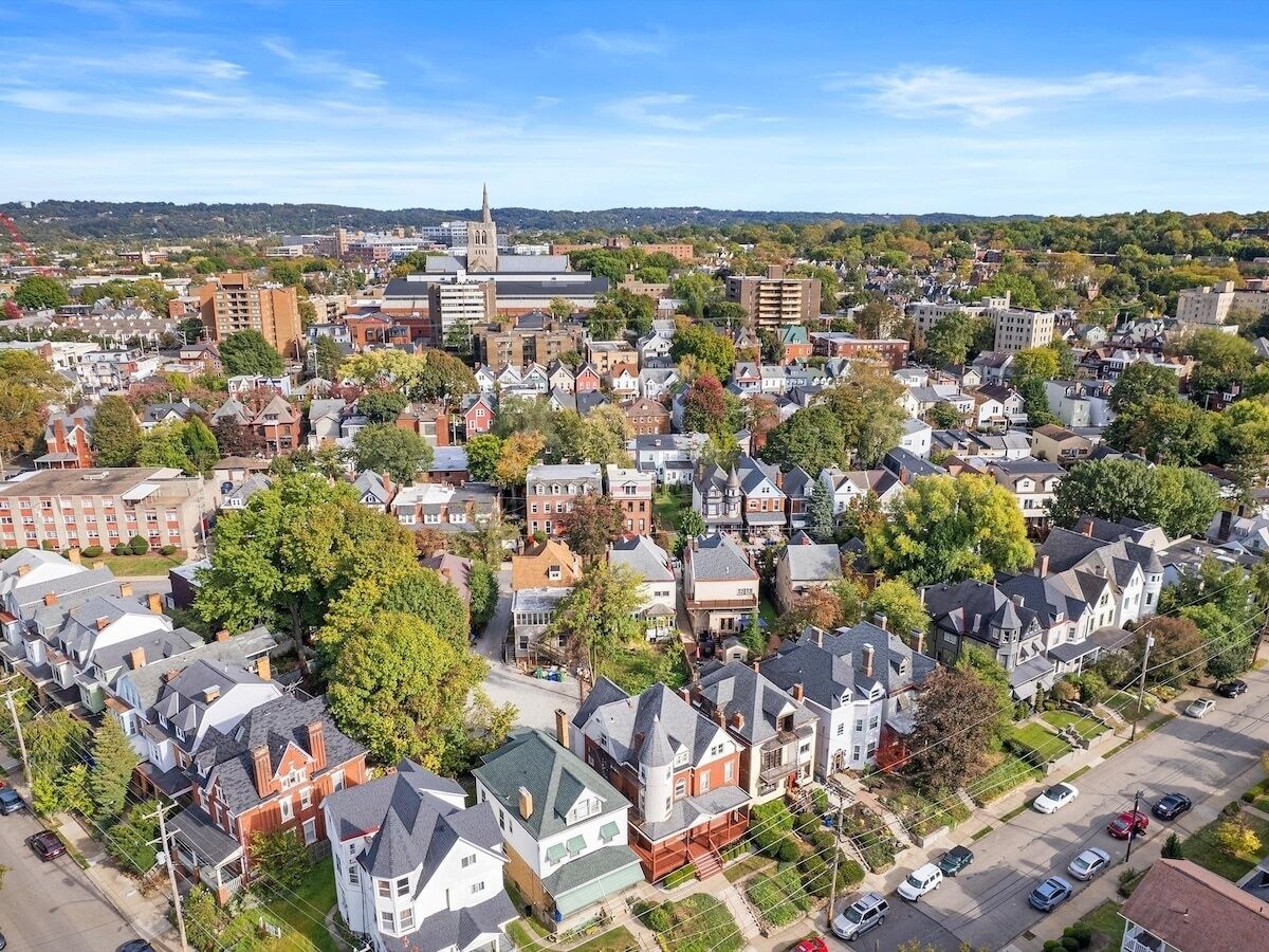 An aerial view of a residential area with houses, a church, and a large building with a spire.