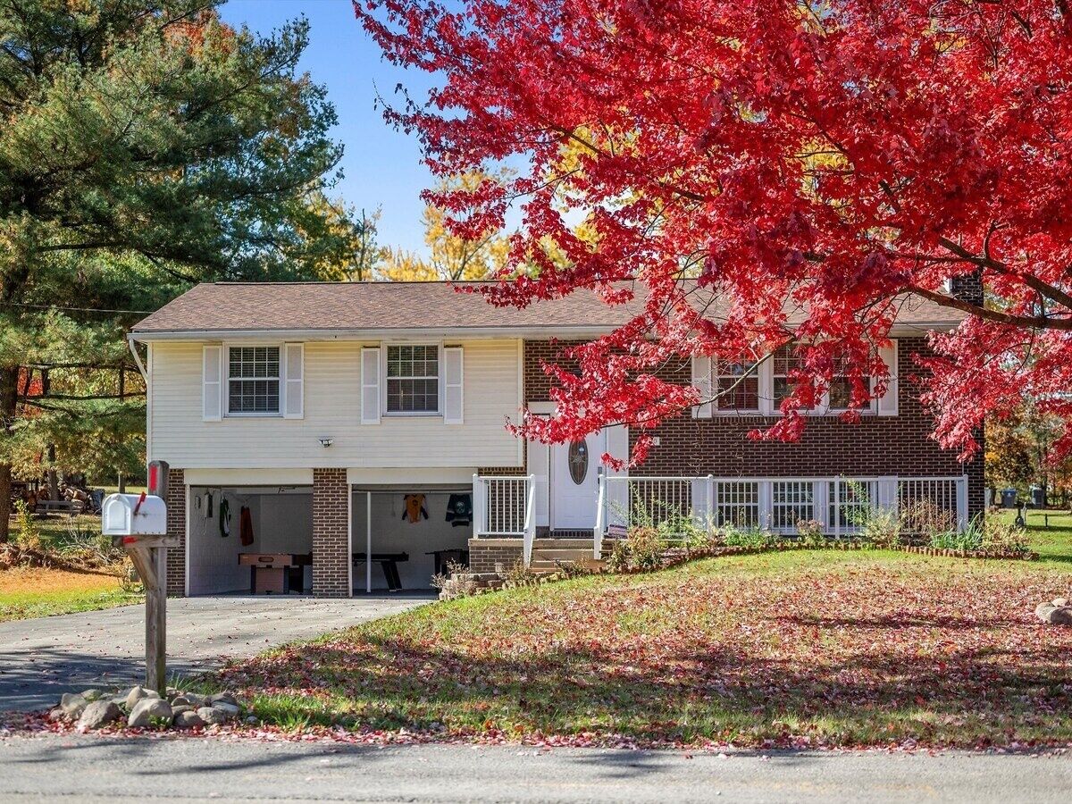 A two-story house with a garage, a front porch, and a well-maintained lawn.