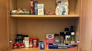 A kitchen pantry with shelves stocked with food items, spices, and condiments. - Emerald Lodge quiet efficiency (Middletown)
