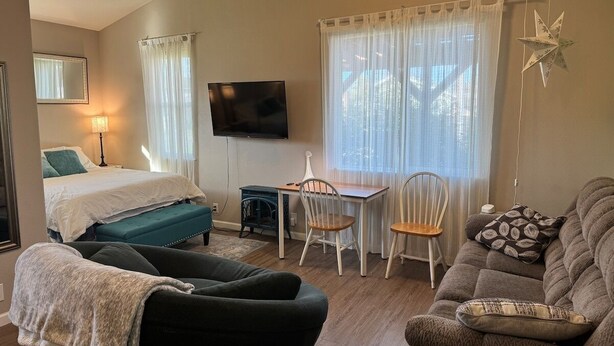 A cozy room with a bed, a sofa, a table, and chairs. - Emerald Lodge quiet efficiency (Middletown)