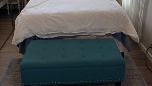 A bedroom with a large bed, two bedside tables with lamps, a mirror, and a window with curtains. - Emerald Lodge quiet efficiency (Middletown)