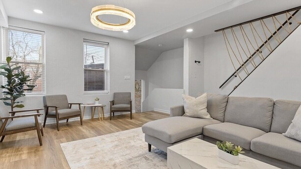 Een moderne woonkamer met een hoekbank, een salontafel en een eetgedeelte met stoelen.