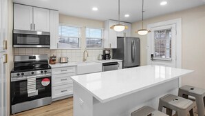 Una cocina moderna con armarios blancos, electrodomésticos de acero inoxidable y una isla grande.