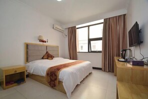 A hotel room with a bed, bedside table, TV, and a window with curtains. - Zhongguo Maidi Express Hotel (Zhongmu)