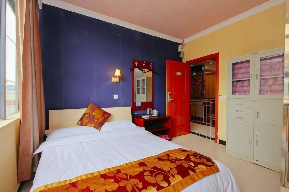 Un dormitorio con cama, cómoda, espejo y armario.