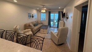 Ein geräumiges Wohnzimmer mit einer Couch, Sesseln, einem Couchtisch und einem Essbereich mit Tisch und Stühlen.