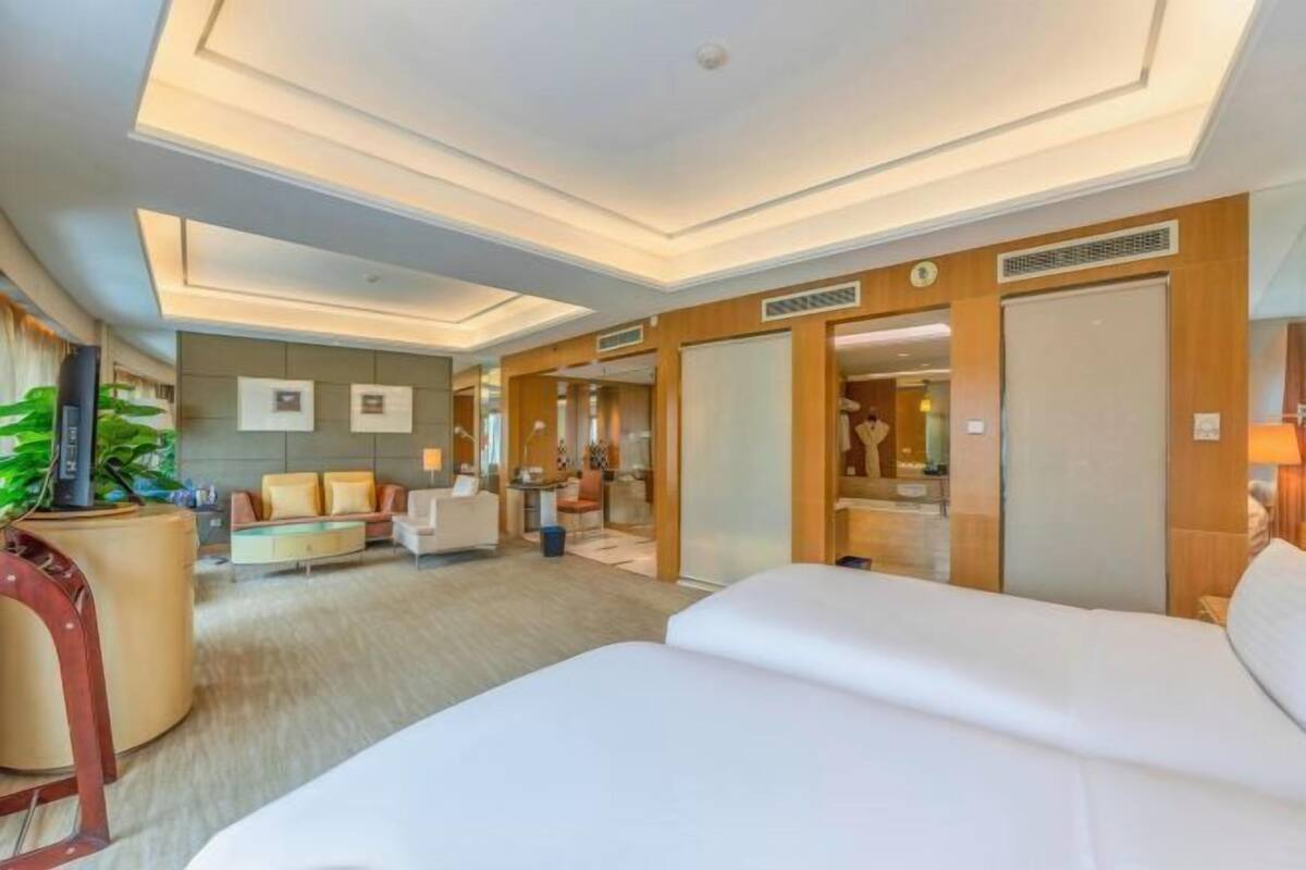 Une chambre d’hôtel avec un grand lit, un canapé, un bureau et un coin repas.