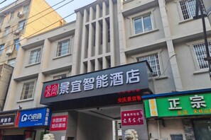 A hotel with a prominent signboard, multiple windows, and a visible storefront with signage. - Jingyi Boutique Hotel (Anqing Petrochemical No.1 Middle School) (Anqing)