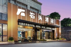 A hotel with a modern facade, large glass windows, and a sign indicating it is a Stone Hotel. - Stone Hotel (Kaili Downtown Wanda Plaza) (Kaili)