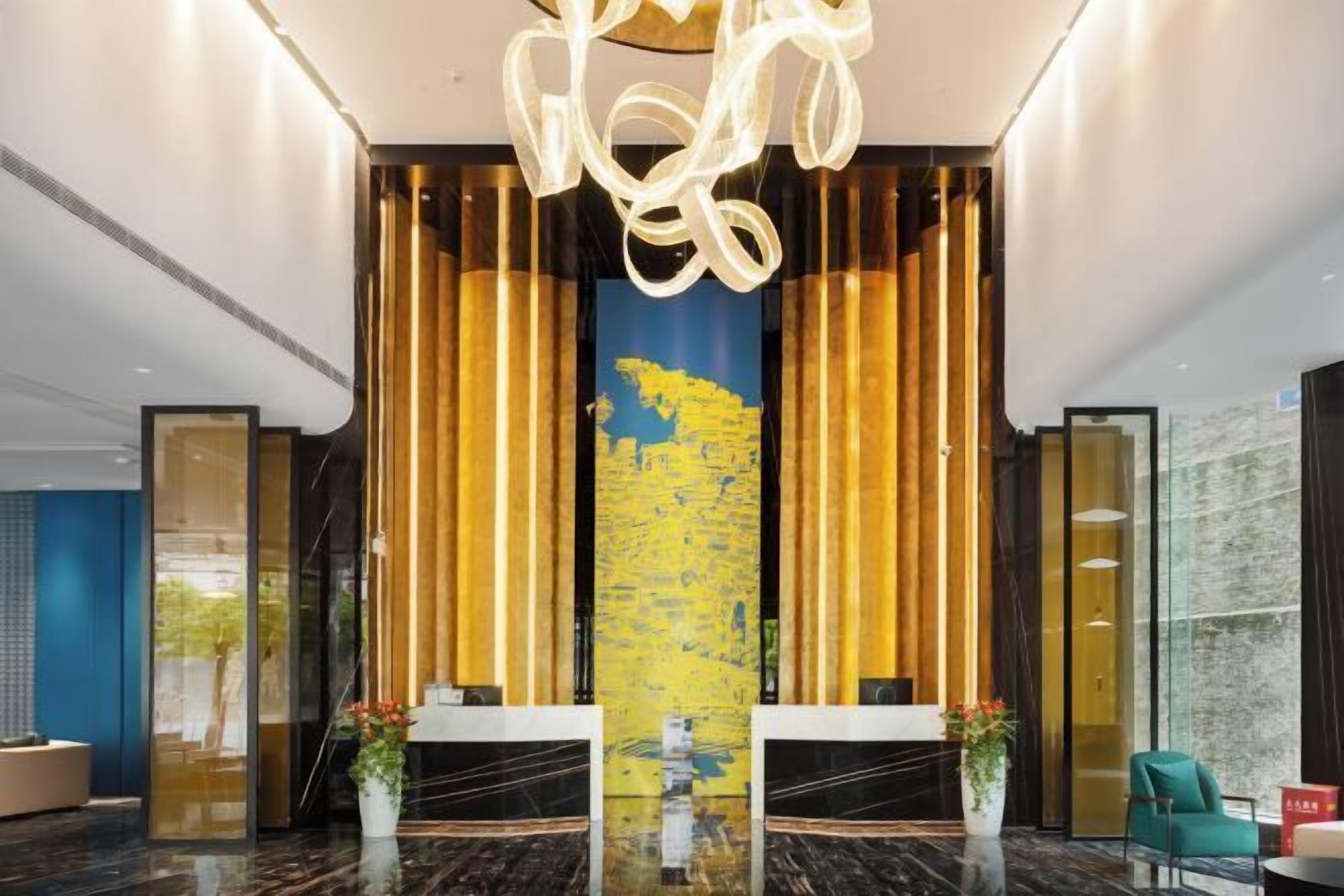 A modern lobby with a reception desk, a large abstract painting, and vertical wooden panels.