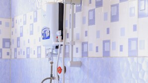 Une douche équipée d’un pommeau de douche à main et d’une pompe à eau portative.