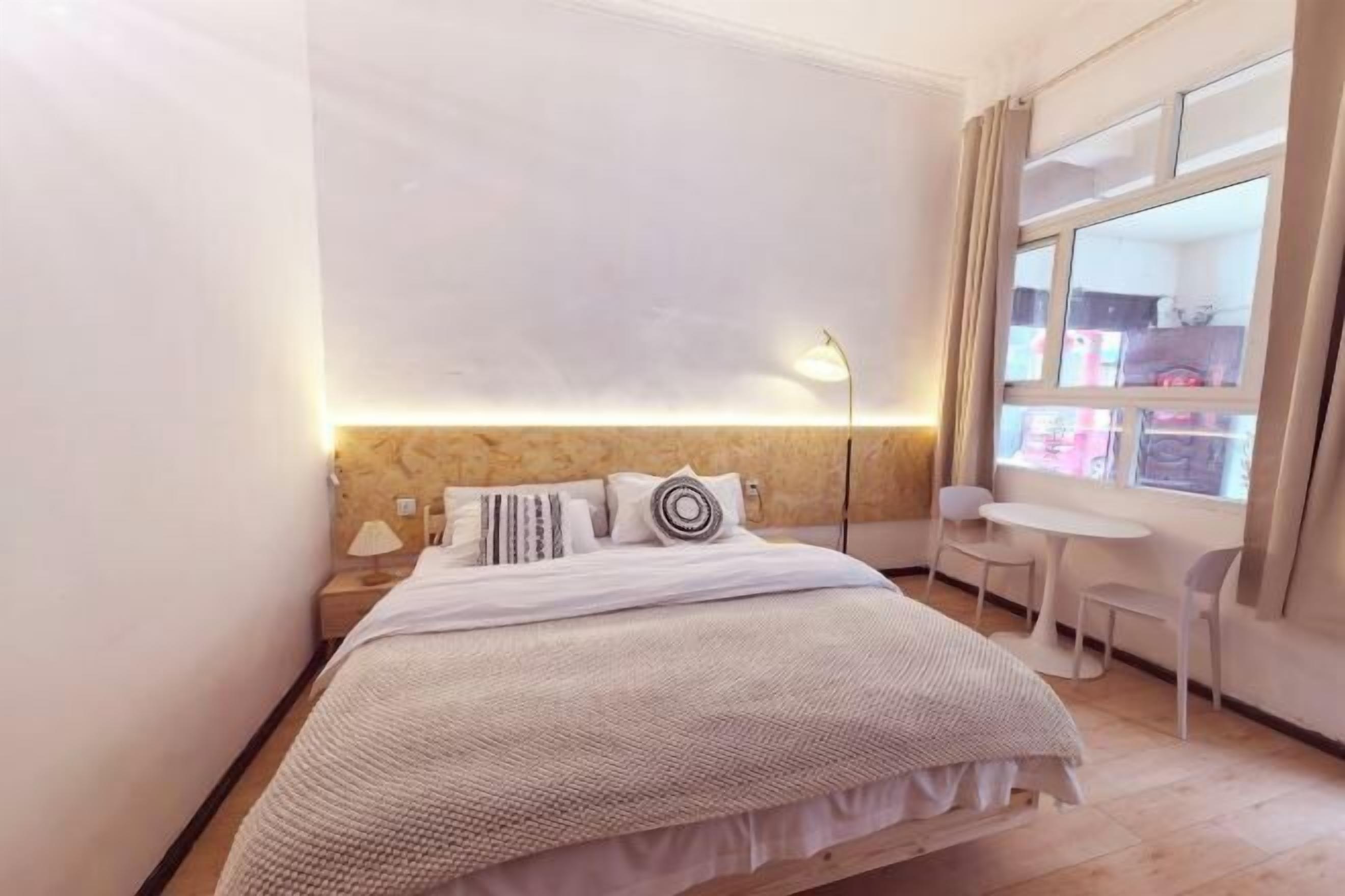 Une chambre à coucher avec un lit, une lampe de chevet et une fenêtre donnant sur un beau paysage.