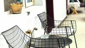 Un petit espace extérieur aménagé avec une table ronde et deux chaises en métal.