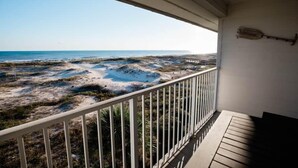 A balcony with a view of a beach and a baseball bat on the wall. - Gulf Shores Plantation 3305 (Gulf Shores)