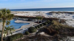 A beach resort with a swimming pool, palm trees, and a sandy beach. - Gulf Shores Plantation 3305 (Gulf Shores)