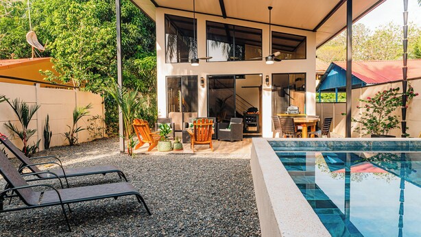 Uma casa moderna com piscina, área de estar externa e espaço para refeições.