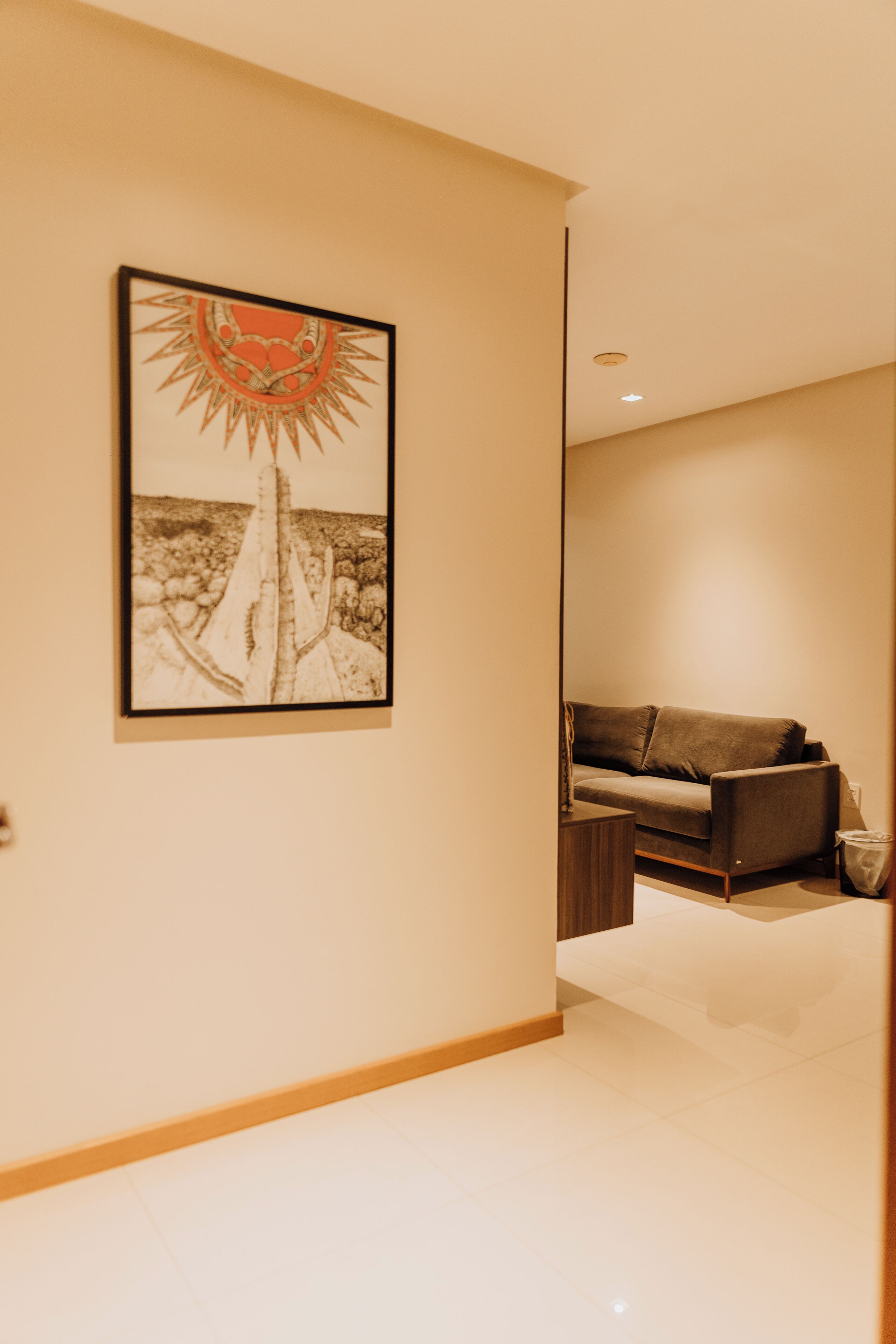 Een moderne woonkamer met een bank, een salontafel en een inlijsting kunstwerk aan de muur.