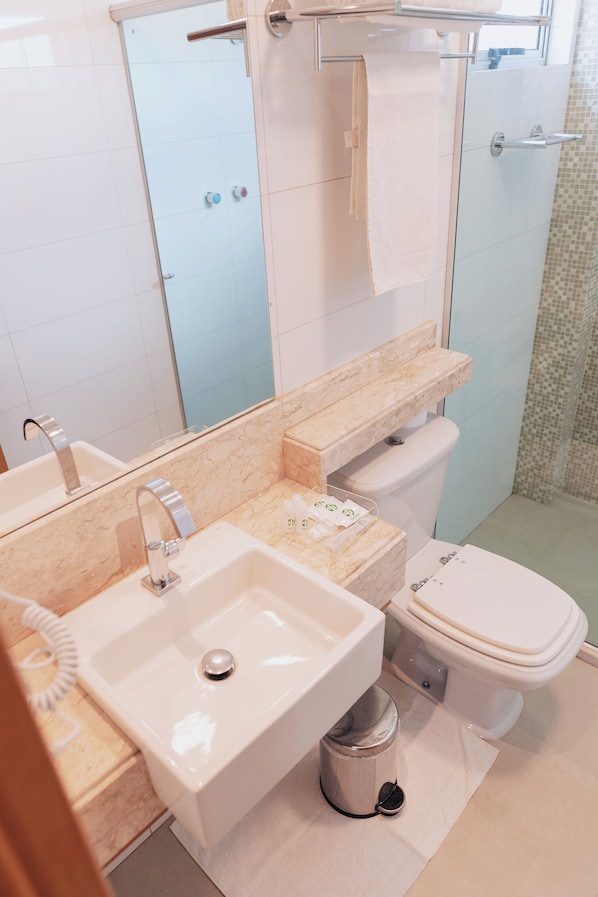 A bathroom with a sink, mirror, toilet, and shower. - Hotel do Sertão (Custódia)