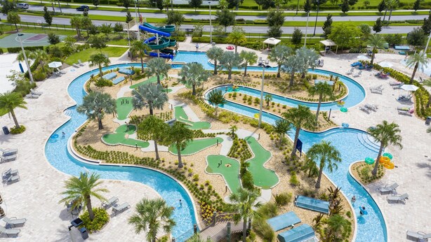 A large outdoor swimming pool with multiple lanes, surrounded by palm trees and sun loungers. - 4731-103 Stay Magical • 2BR with Mickey Room & More (Kissimmee)