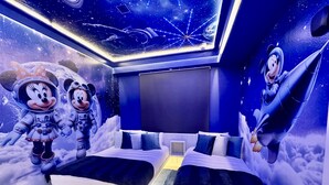 A room with two beds, a large screen, and space-themed wall art. - 4731-103 Stay Magical • 2BR with Mickey Room & More (Kissimmee)