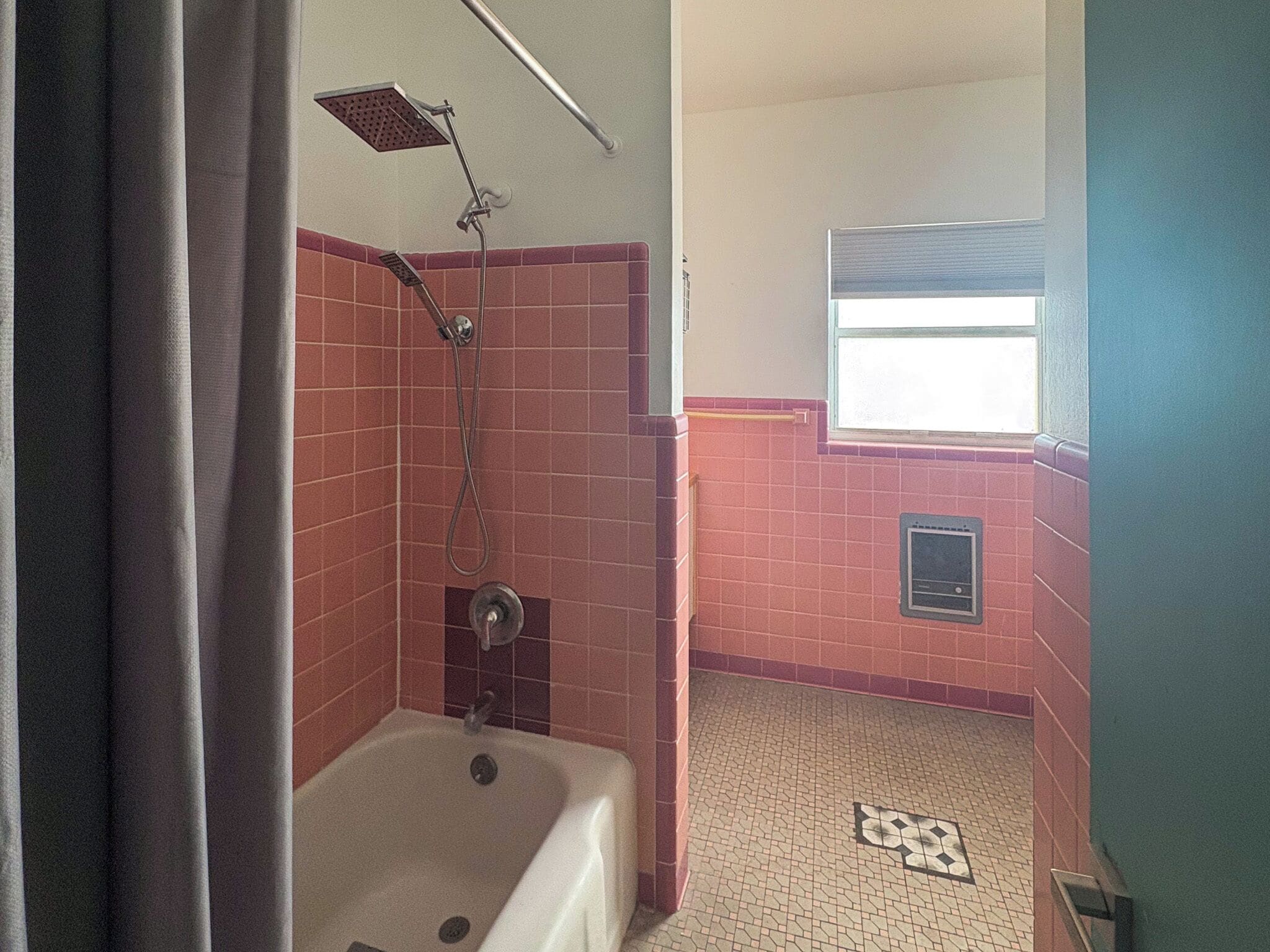 A bathroom with a bathtub, a shower, and a window.