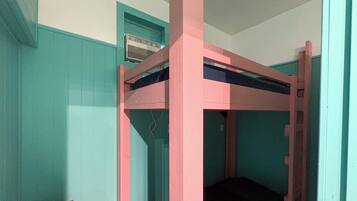 A bunk bed with a pink frame and a single bed below.