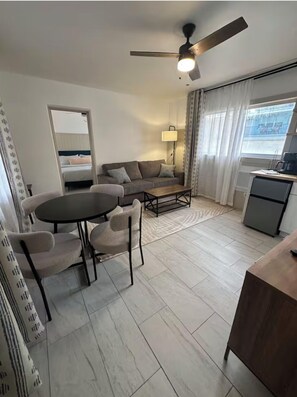 Suite, 1 très grand lit et 1 canapé-lit, coin cuisine, vue piscine | Coin séjour