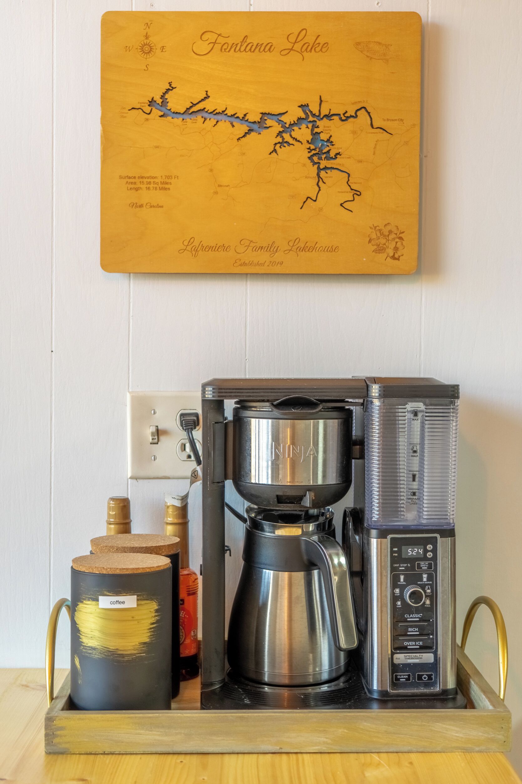 A coffee maker on a tray with a map of Fortara Lake and a label for the Leprendero Family Lakehouse.