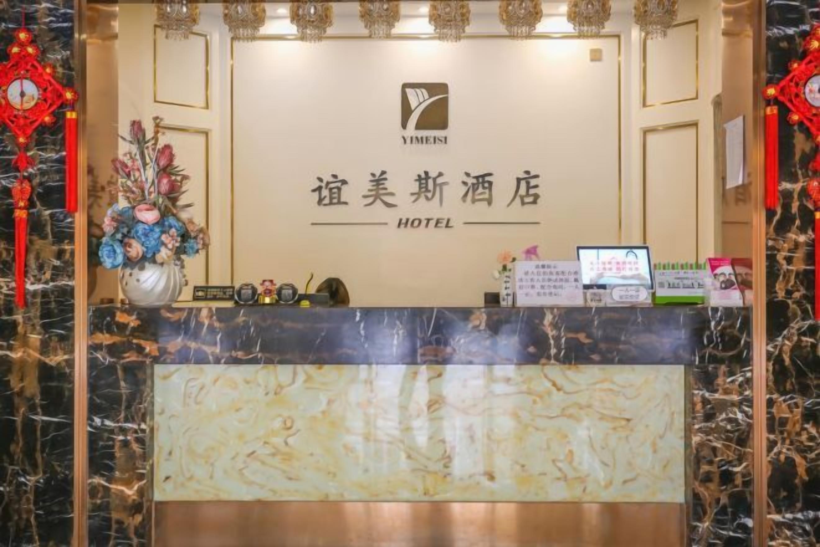 A hotel reception desk with a marble counter, a logo, and a sign in a foreign language.