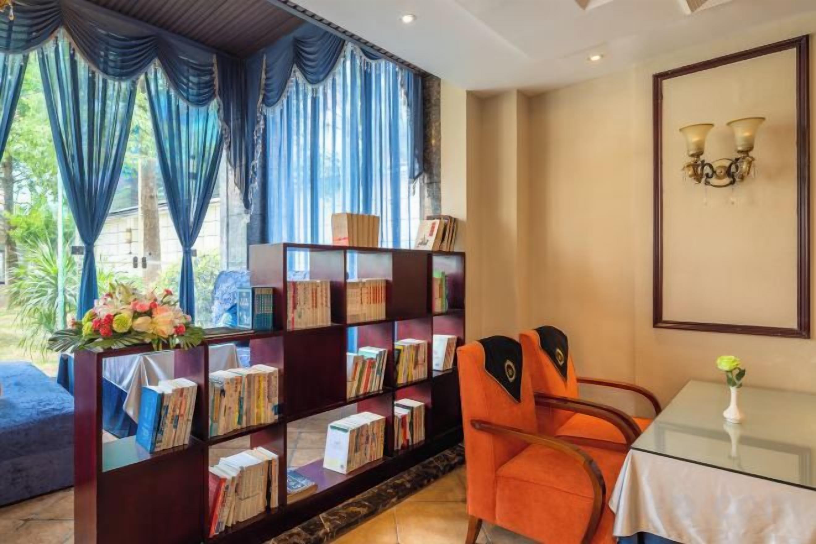 A room with a bookshelf, a table with a vase, and a chair.