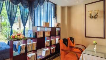 A room with a bookshelf, a table with a vase, and a chair.